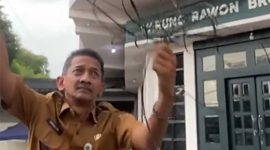 Kades Kepatihan Jombang, Erwin Pribadi saat menunjukkan kabel fiber optik yang distop pemasangannya karena dinilai terlalu banyak dan semrawut.