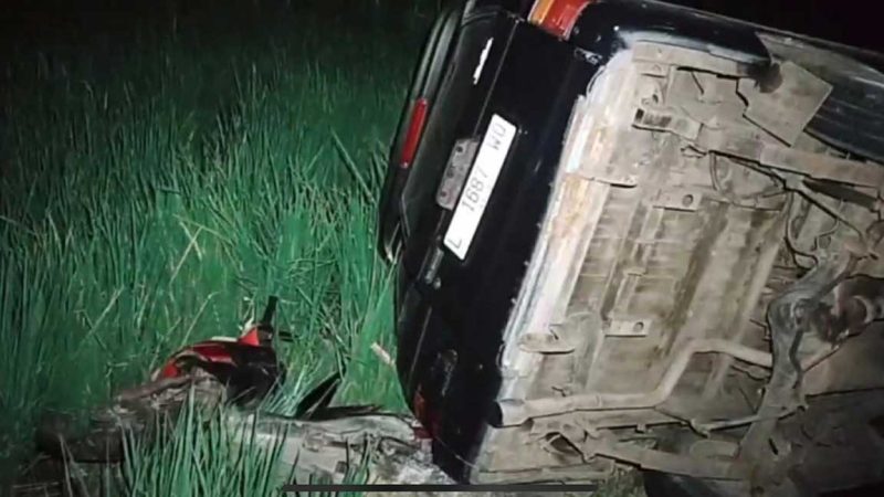 Minibus biru jenis Isuzu Panther nopol L-1687-WD terguling ke area persawahan setelah menabrak sepeda motor yang terparkir di tepi jalan Desa Sumengko, Kecamatan Sukomoro, Nganjuk.