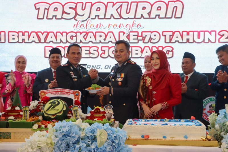 Kapolres Jombang AKBP Ardi Kurniawan memberikan potongan tumpeng kepada Kompol Bambang Setyobudi dalam acara Tasyakuran Hari Bhayangkara ke-79. (Foto: dok)