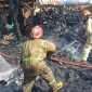 Petugas sedang melakukan pembasahan di area gudang rongsok di Johowinong, Kec Mojoagung, Jombang yang terbakar.