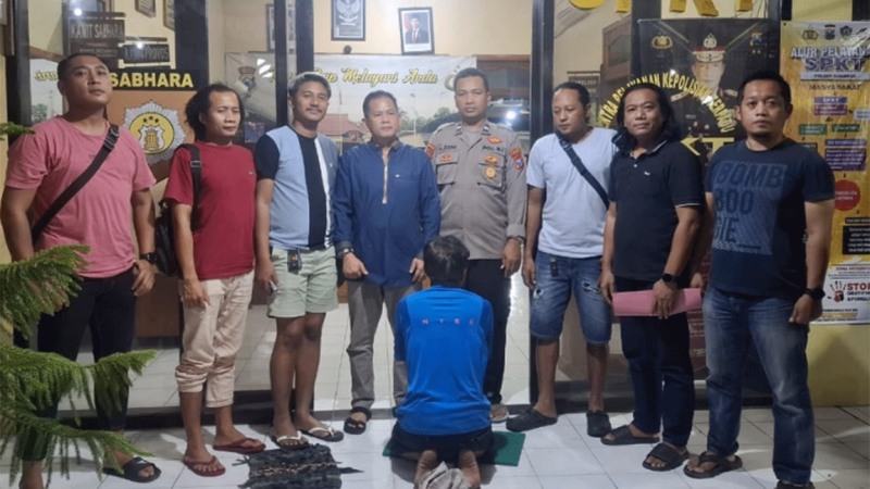Pria asal Jombang yang tertangkap warga di Lamongan (membelakangi) gegara mencuri motor, saat diamankan polisi Lamongan.