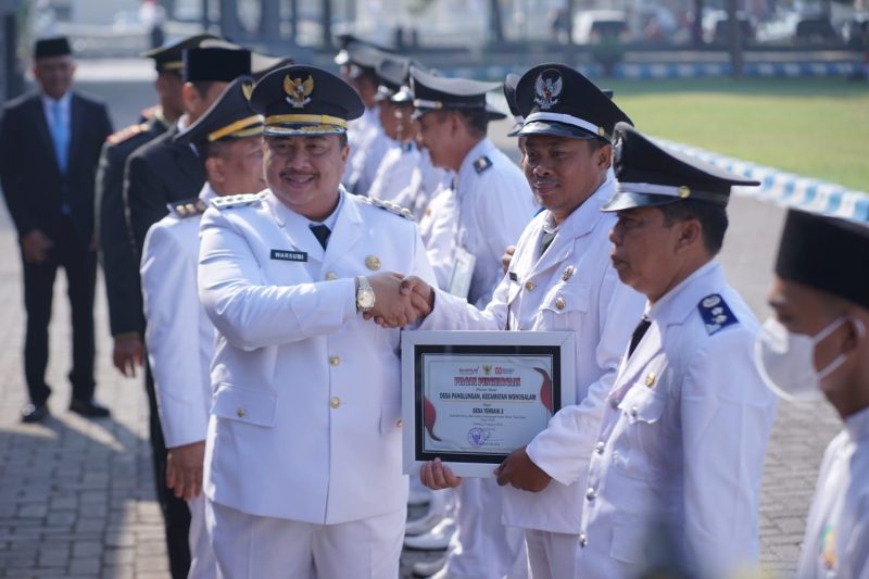 Bupati Jombang Warsubi memberikan penghargaan kepada kepala desa dalam Upacara HUT ke-80 RI di Alun Alun Jombang.