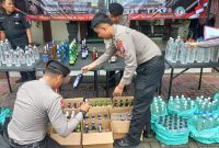 Polisi sedang menata barang bukti ratusan botol minuman keras (Miras) untuk konferensi pers di Polres Jombang.