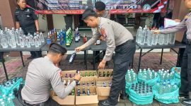 Polisi sedang menata barang bukti ratusan botol minuman keras (Miras) untuk konferensi pers di Polres Jombang.