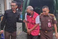 Hariyono (69), pria yang terjerat kasus korupsi dana hibah PSSI Jombang, saat digelandang petugas di Kejari Jombang.
