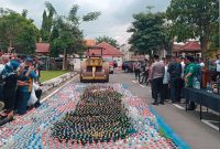Proses pemusnahan barang bukti ribuan botol minuman keras (Miras) di halaman Polres Jombang.
