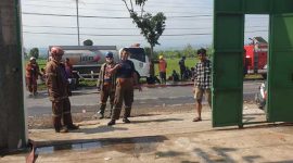 Petugas sedang melakukan pembasahan di areal gudang serbuk kayu yang terbakar. Lokasinya, di Desa Rejoslamet, Kecamatan Mojowarno, Jombang.